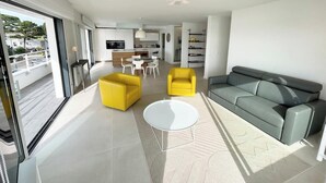 A modern living room with a grey sofa, two yellow armchairs, and a white coffee table.