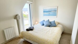 Ein Schlafzimmer mit einem Bett, einem Heizkörper, einem Fenster und einem Bild an der Wand.