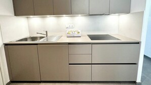 Une cuisine moderne équipée d’une cuisinière intégrée, d’un évier et d’un plan de travail.