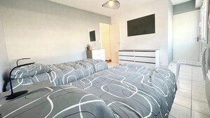Ein modernes Schlafzimmer mit einem großen Bett, einem Nachttisch, einem Sessel und einem Kleiderschrank.