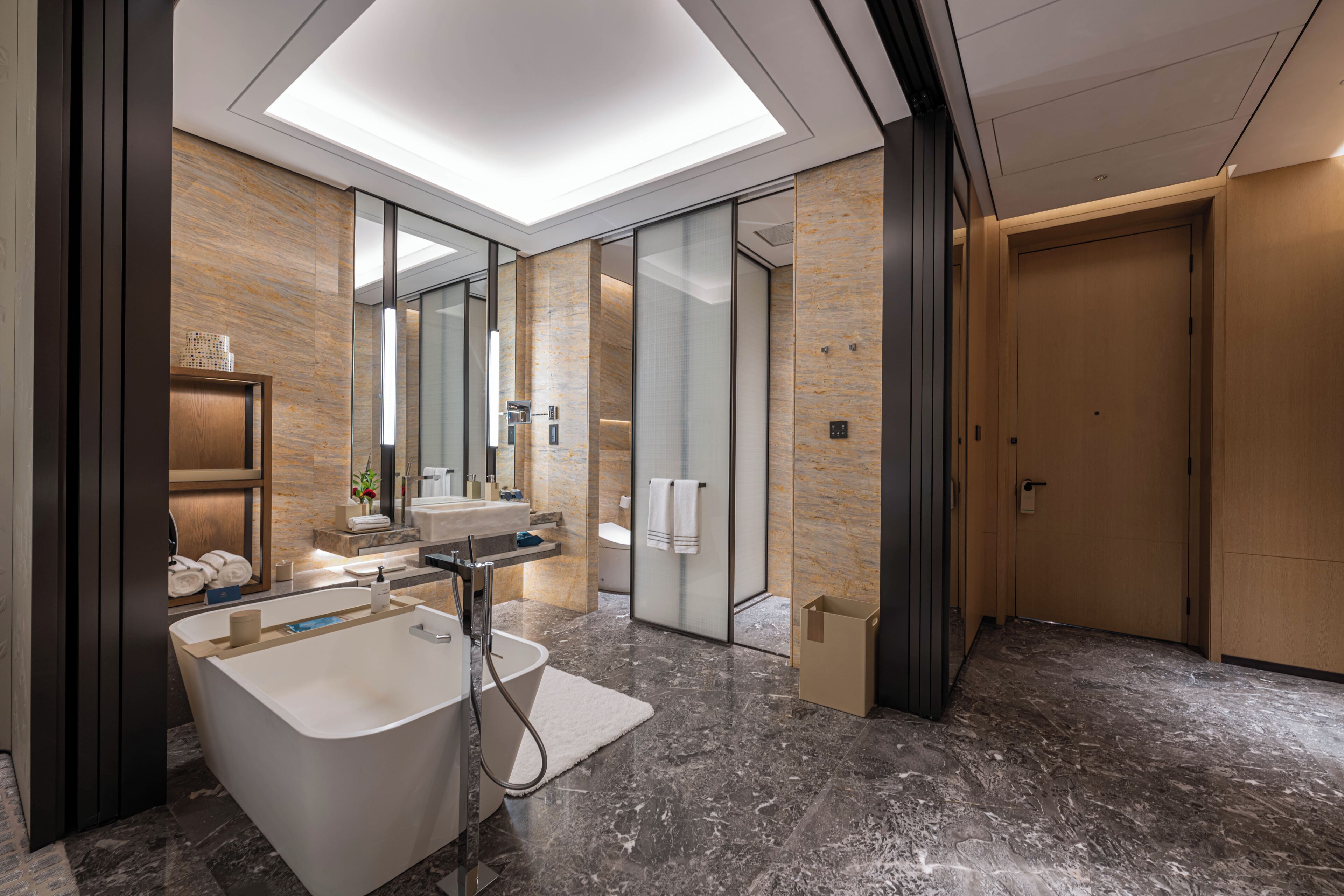 A modern bathroom with a freestanding bathtub, a vanity with a mirror, and a glass-enclosed shower area.