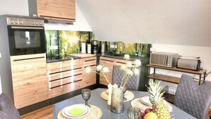 A modern kitchen with wooden cabinets, a built-in oven, and a microwave. - Vacation apartment Hovest - relaxation for up to 4 guests  (Ostbevern)