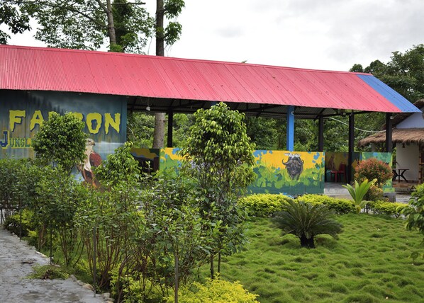 A building with a red roof and colorful murals depicting wildlife.