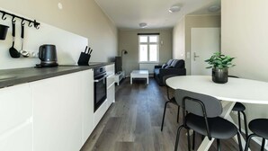 Un espacio habitable compacto con kitchenette, comedor y asientos.