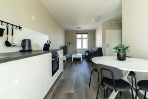 A compact living space with a kitchenette, dining area, and seating.