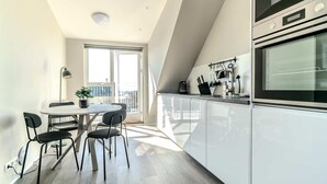 Una cocina moderna con comedor, ventanas amplias y vistas a la ciudad.