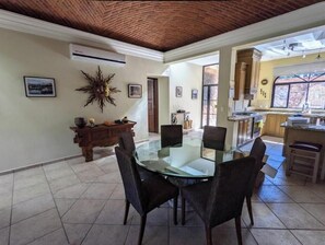 Enjoy meals in this stylish dining area with a glass-top table and six chairs, surrounded by artwork and a decorative sunburst.