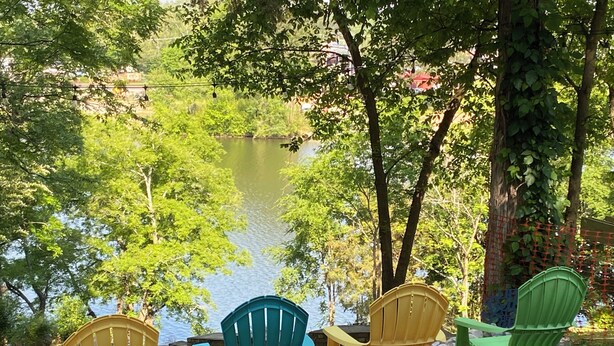 Outdoor seating with chairs facing a body of water, surrounded by trees and a fence. - Hot Tub / Top 1% /  Kayaks /  950 Mbp /  Pets /  PickleB (Hot Springs)