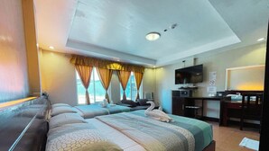 A hotel room with two beds, a desk, a TV, and a window with curtains. - Siayan Travellers Inn Manila powered by Cocotel (Pasay)