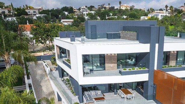 A modern two-story building with a rooftop pool, outdoor seating, and a glass facade. - Buganvilia - Luxury villa - private pool by HD (Almancil)
