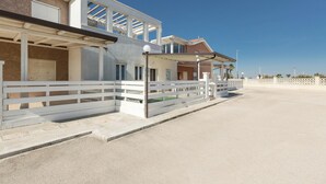 A modern two-story house with a covered patio and a white fence. - 3866 Horizont - Bilo Standard by Barbarhouse (Margherita di Savoia)