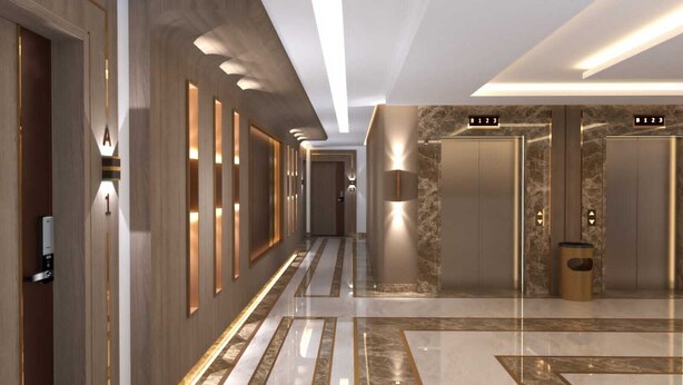 A modern hotel corridor with a marble floor, wooden paneling, and illuminated wall sconces. - Tamaya Alkhobar (Al Khobar)