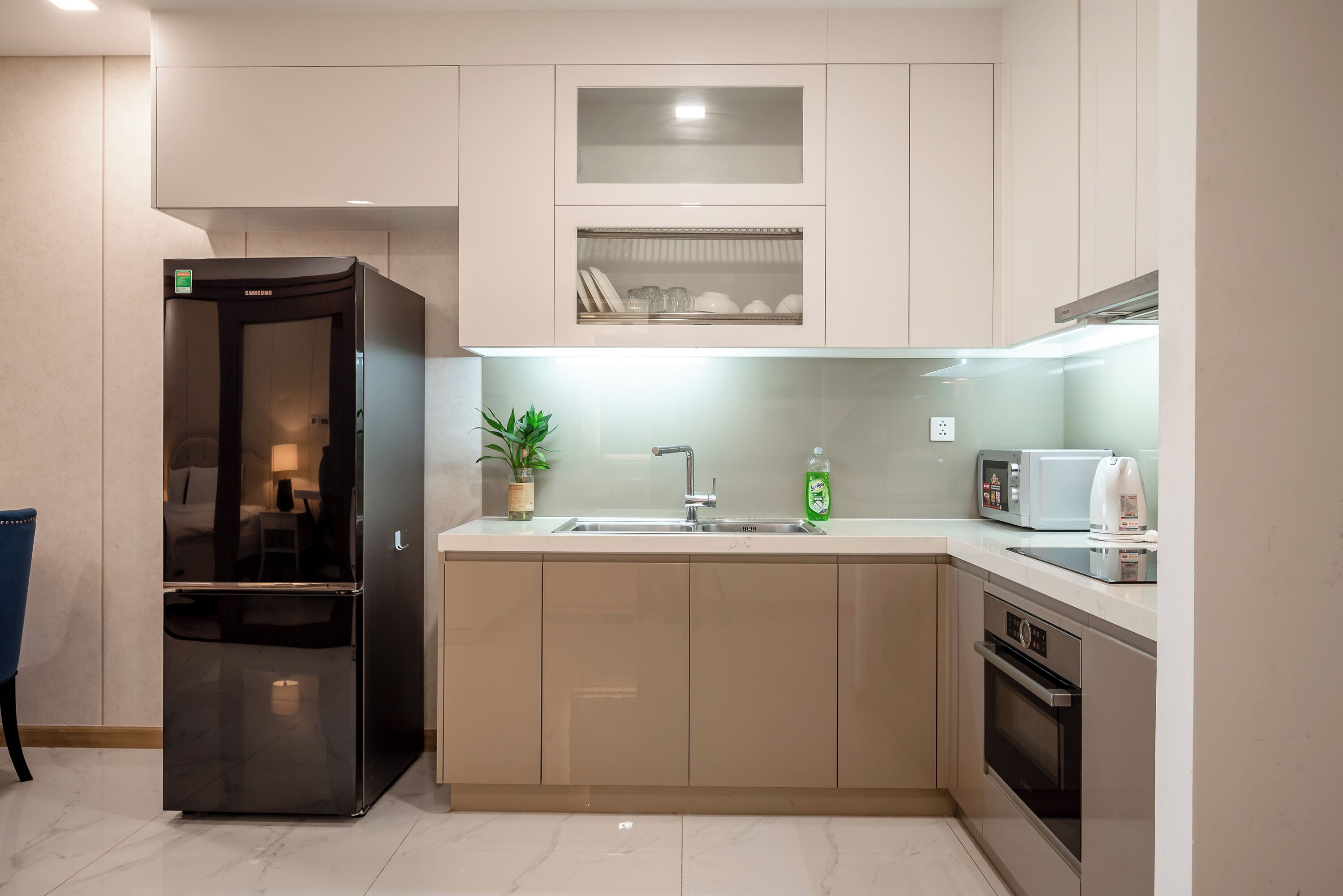 Una cocina moderna con refrigerador empotrado, microondas, horno y lavaplatos.