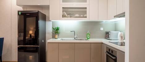Una cocina moderna con refrigerador empotrado, microondas, horno y lavaplatos.