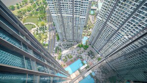 Un immeuble de grande hauteur, doté de nombreux étages, de grandes fenêtres et d’une cour intérieure avec une piscine.