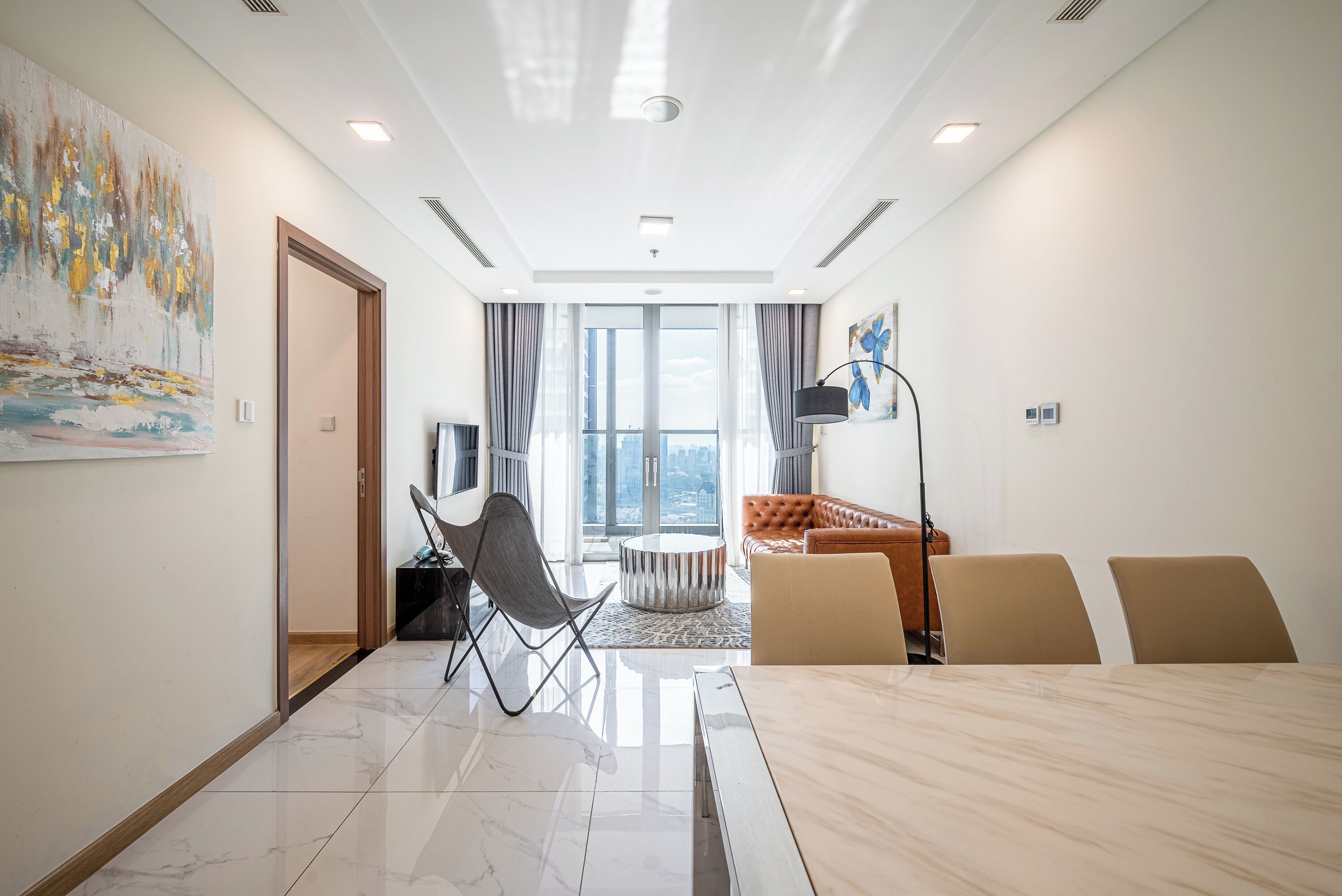 Et moderne hotelværelse med stort vindue, spiseplads og opholdsområde.