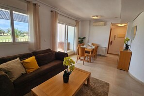 Ein Wohnzimmer mit einer Couch, einem Couchtisch und einem Essbereich mit Stühlen und einem Tisch.