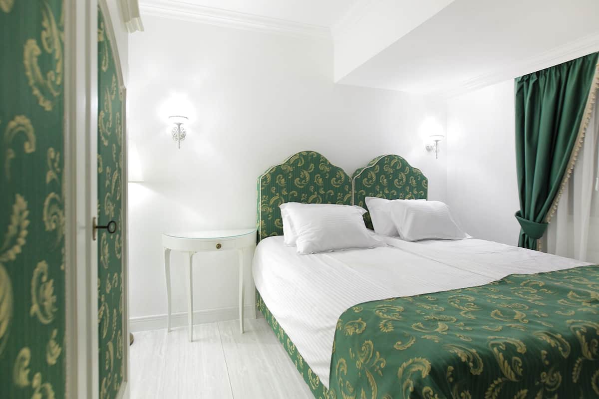 Een hotelkamer met een bed, nachtkastje en bedtafel.