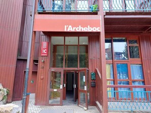 Un edificio rosso con un'insegna che recita "l'Archeboc".