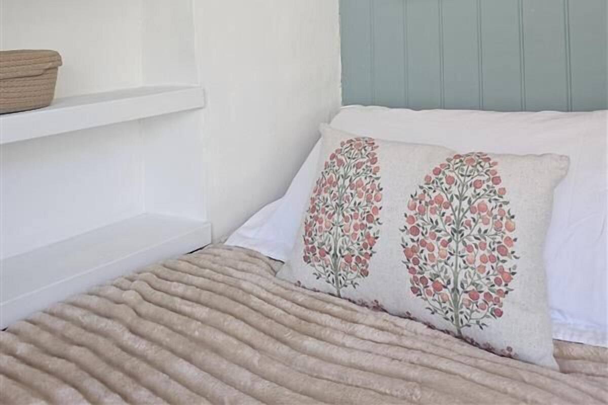 A bedroom with a bed, a wall-mounted map, and white shelves with decorative items.
