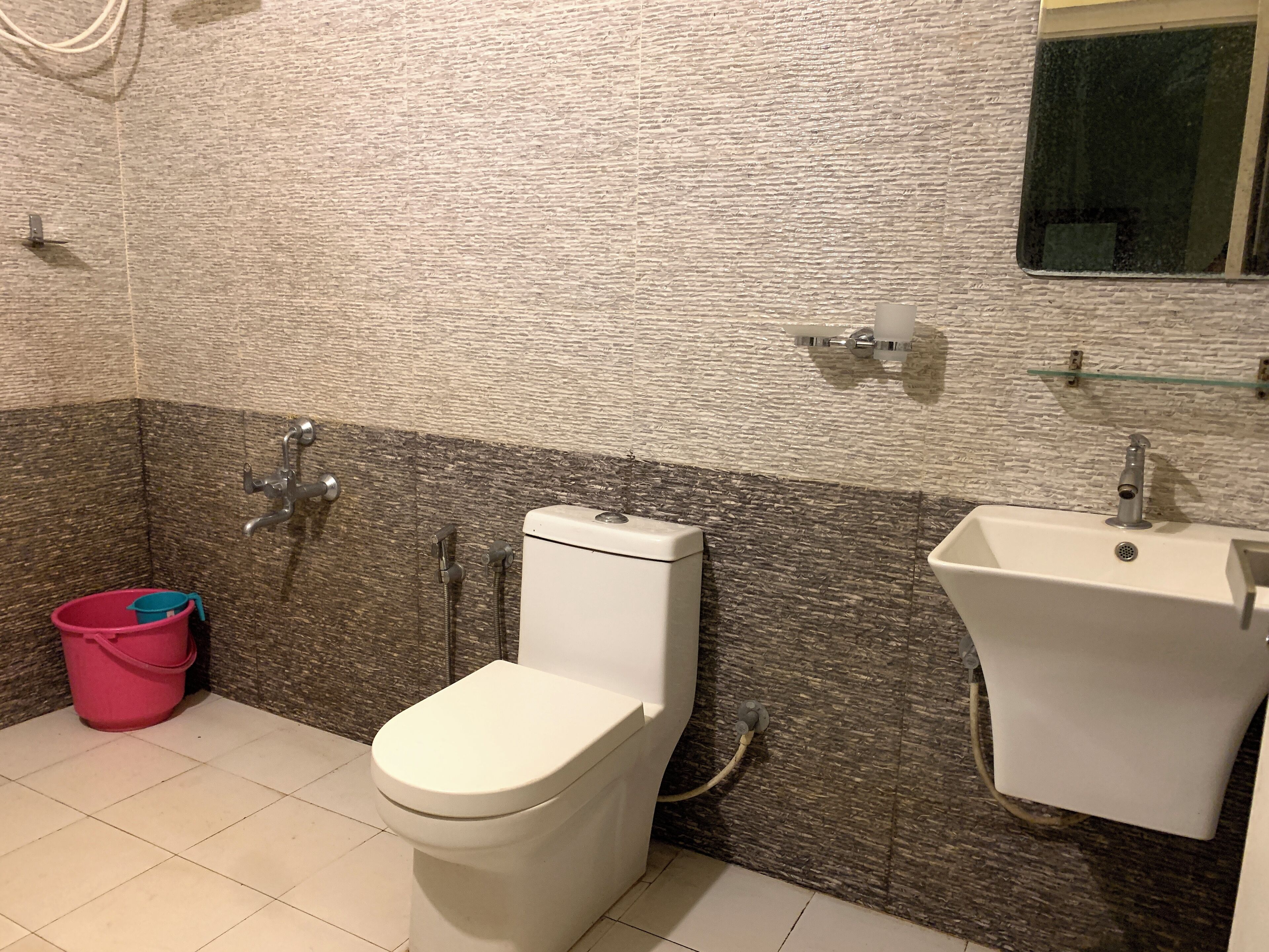 A bathroom with a toilet, bidet, and sink.