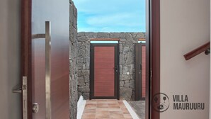 A doorway leading to a stone-walled area with a red door and a tiled floor. - Villa Mauruuru 10 Minutes Walking From Marina Rubicón, Heated Pool&bbq (CN)