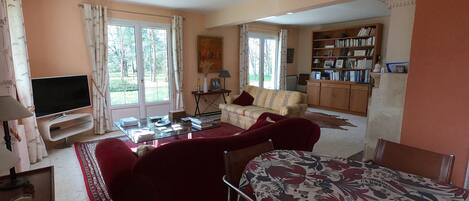 A living room with a sofa, a TV, a coffee table, and a bookshelf.