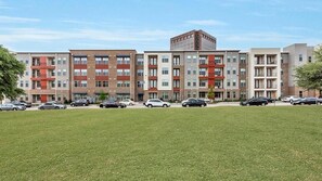 A multi-story apartment building with a parking lot in front.