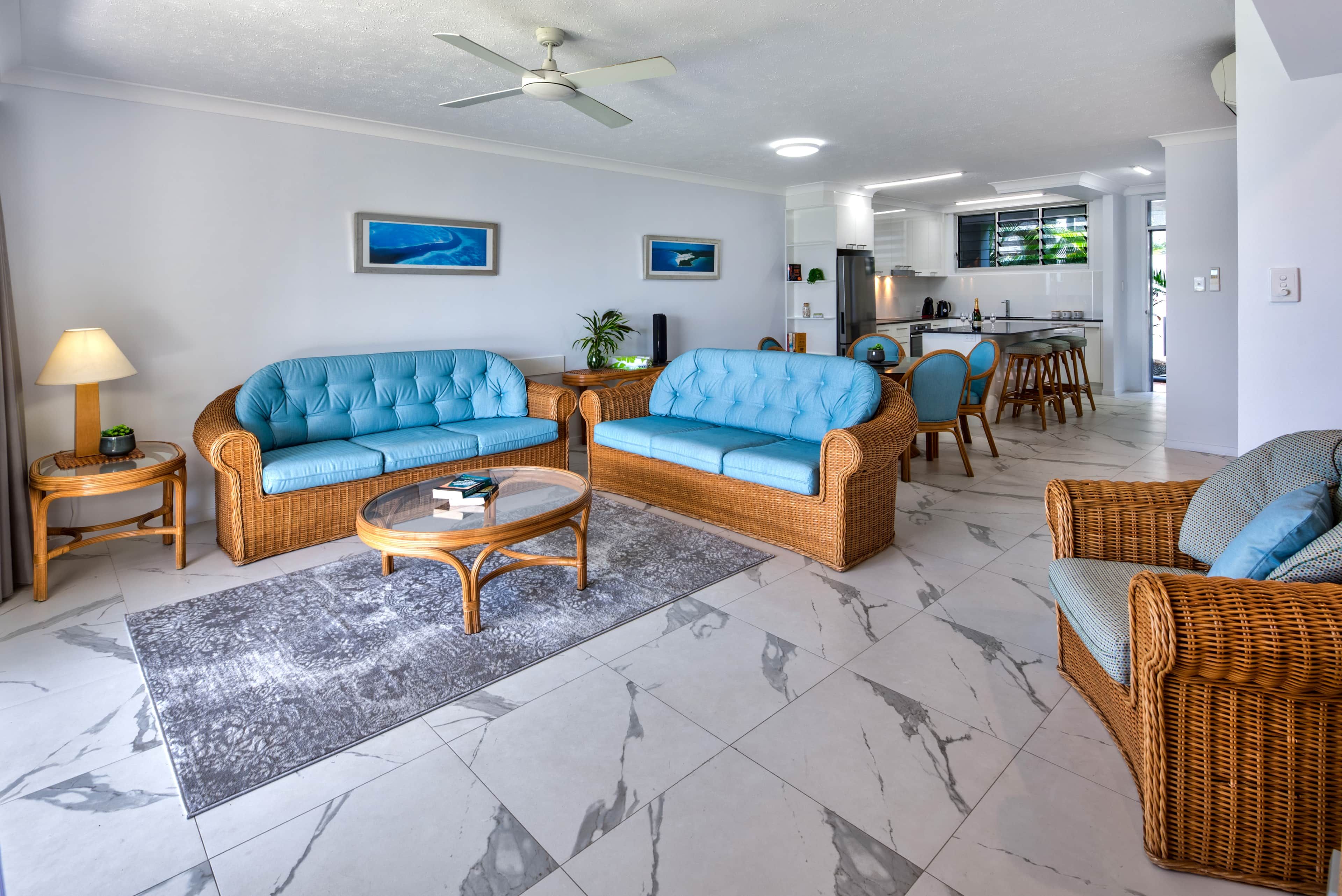 A modern living room with a sofa set, a coffee table, and a dining area with chairs.