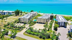 A hotel complex with multiple buildings, a pool, and a beach view. - Kings Crown 118: Remodeled 3 BR Gulf Front Condo! (Sanibel)
