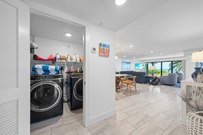 A modern apartment with a laundry area, a dining area, and a living room with a view. - Kings Crown 118: Remodeled 3 BR Gulf Front Condo! (Sanibel)