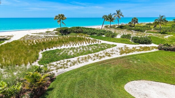A coastal landscape with a beach, palm trees, and a clear sky. - Kings Crown 118: Remodeled 3 BR Gulf Front Condo! (Sanibel)