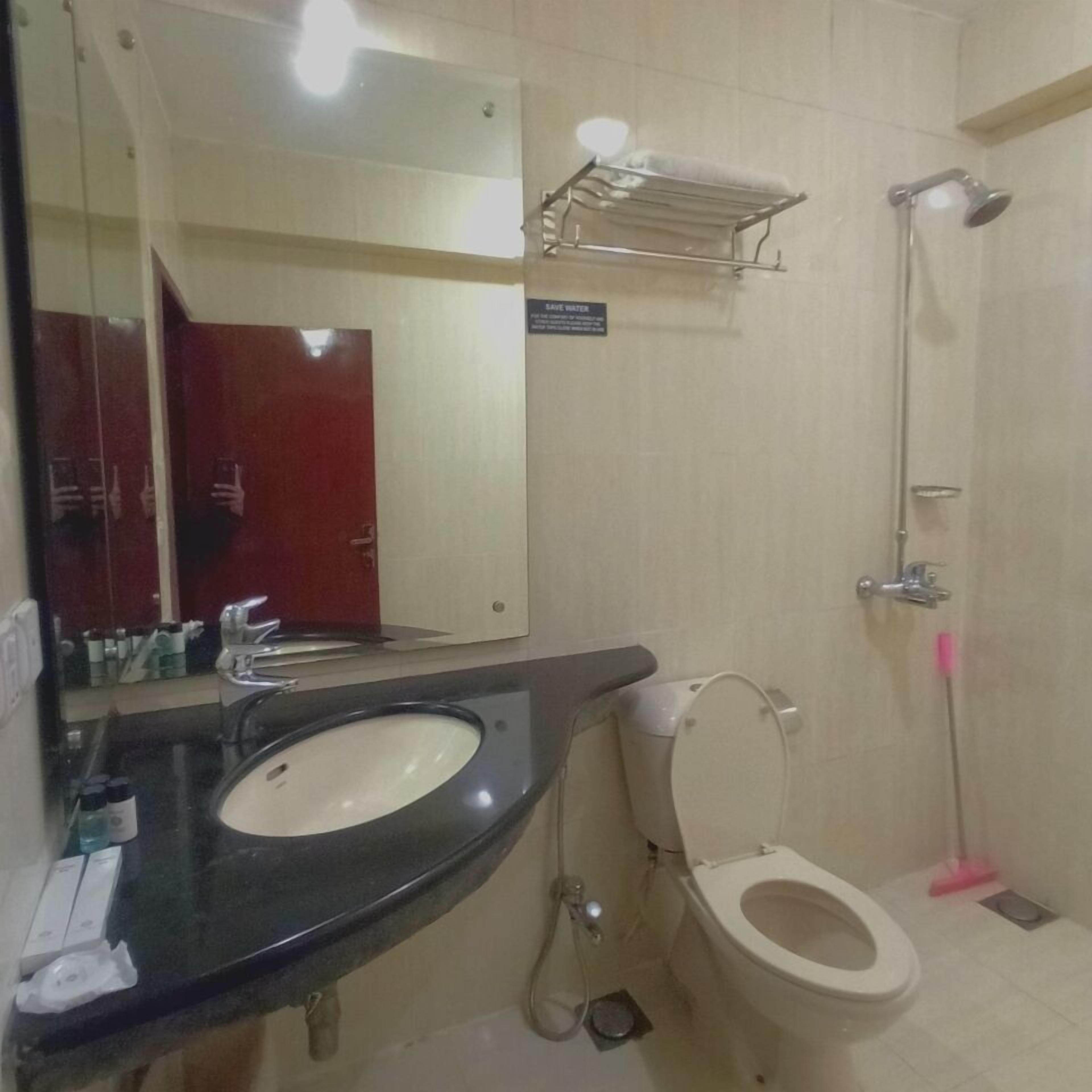 A bathroom with a sink, toilet, and shower.