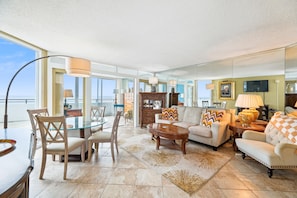 A spacious living area with a dining table, chairs, a sofa, and a coffee table. - Includes Xplorie Activities and Linens. PYRAMID - 1BR Veranda condo w/outdoor pool. (Ocean City)
