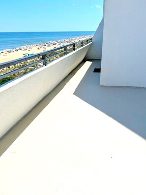 Un balcón con vista a la playa y al mar.