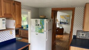 Una cocina compacta con armarios de madera, un refrigerador blanco y una encimera azul.