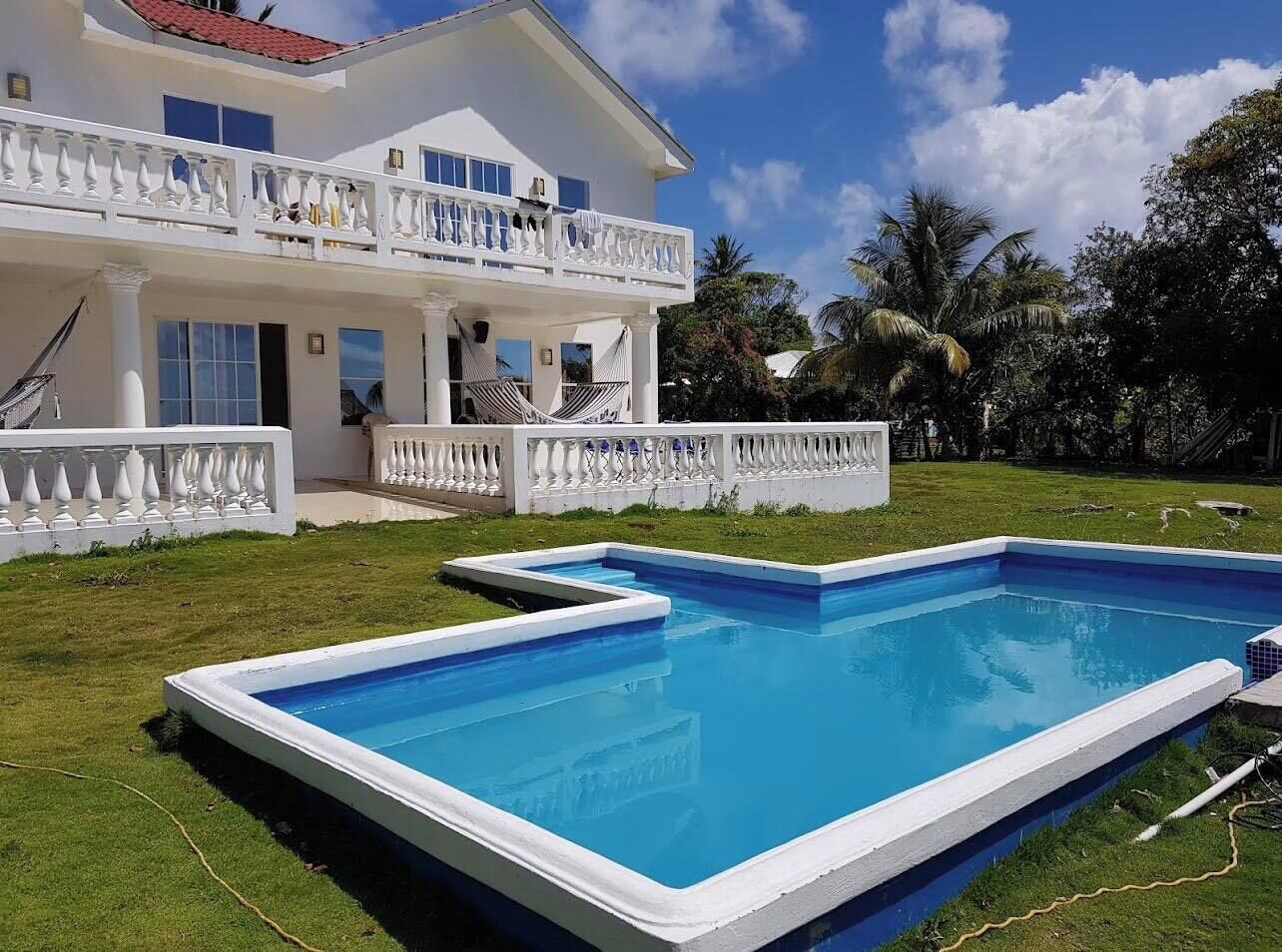Una casa de dos pisos amb una piscina i un balcó.