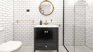 A bathroom with white subway tiles, a black vanity with gold fixtures, and a round mirror. - Arapiles Crash Pad in Natimuk (Natimuk)