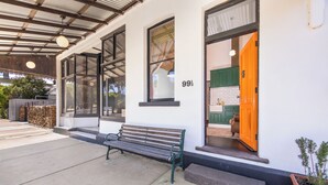A building with a bench outside, a large window with a number, and a door. - Arapiles Crash Pad in Natimuk (Natimuk)