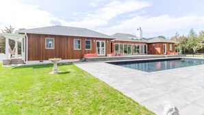 A modern house with a large swimming pool, a covered patio, and a well-maintained lawn. - West Hamptons Zen Retreat (Westhampton)