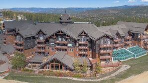 Un chalet à plusieurs étages doté de balcons et situé à proximité d’une piste de ski.