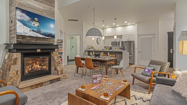Una sala de estar con chimenea, comedor y cocina.