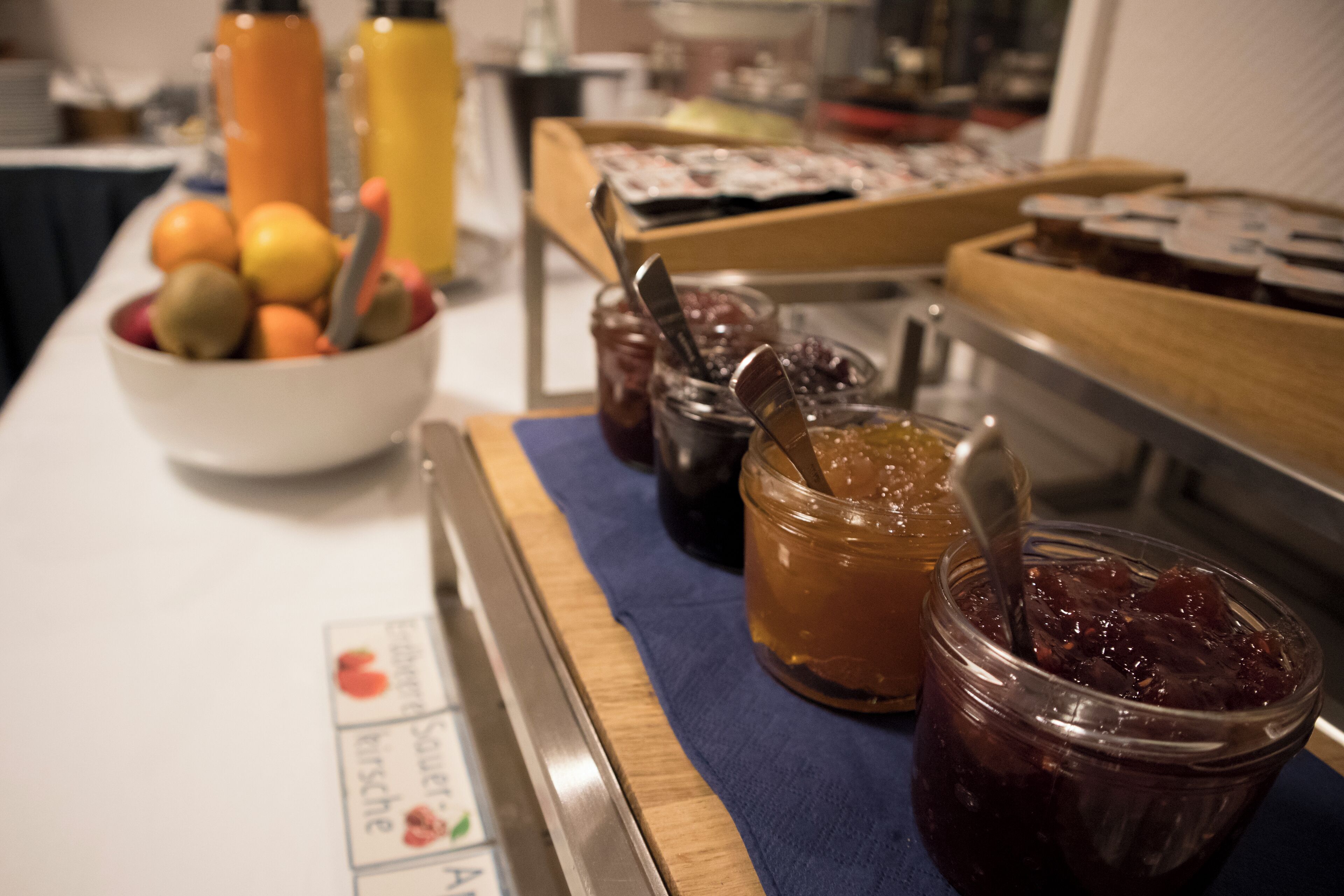 A buffet table with various food items including fruits and condiments.