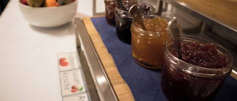 A buffet table with various food items including fruits and condiments.