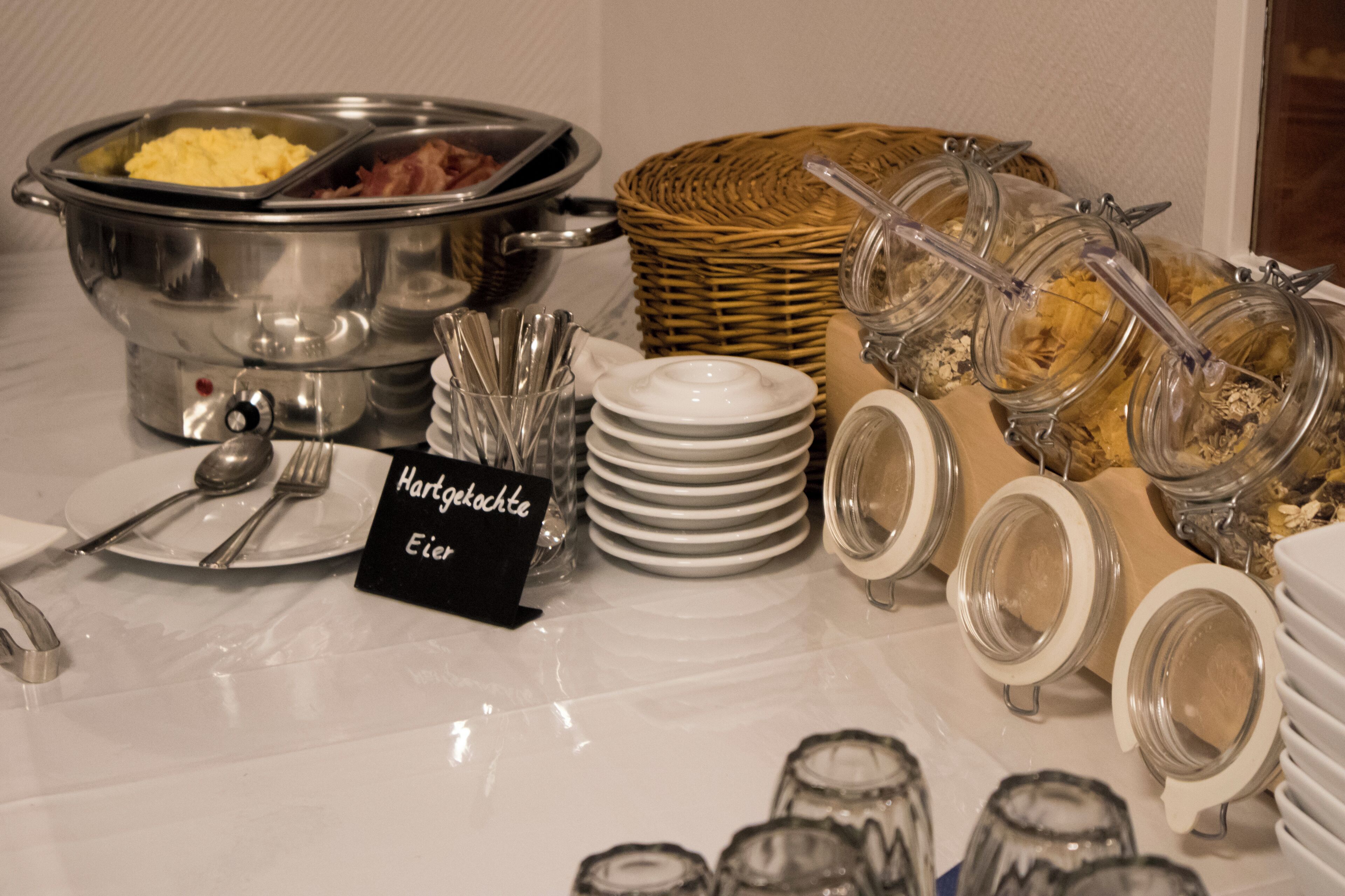 Una barra de buffet con una variedad de alimentos y utensilios.