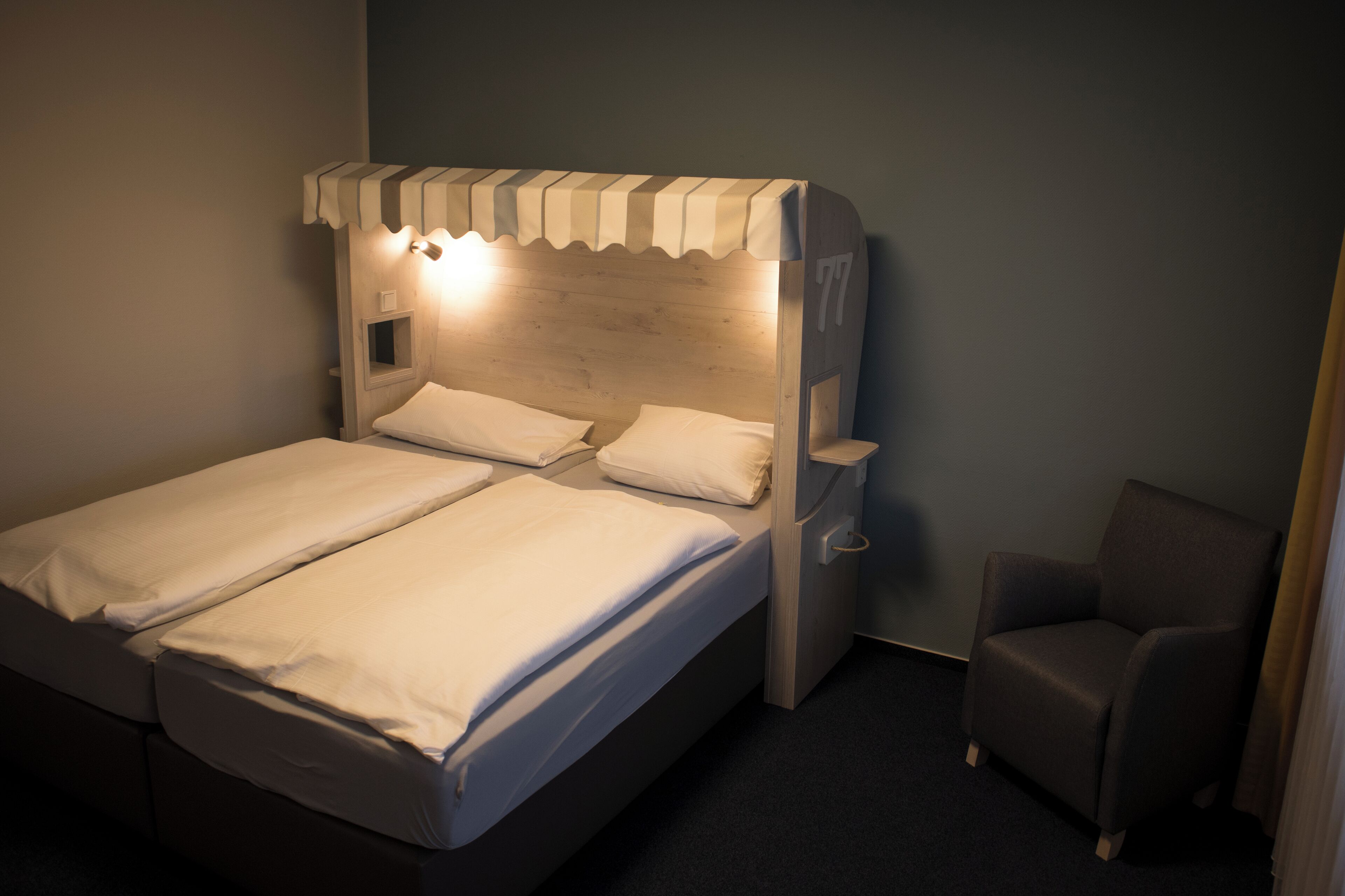Un lit double avec une tête de lit en bois et une petite table de chevet.