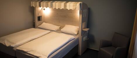 Un lit double avec une tête de lit en bois et une petite table de chevet.