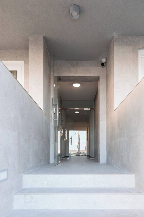 A modern interior with a staircase leading to a bright hallway.