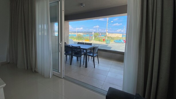 A modern room with a sliding glass door leading to an outdoor area with a table and chairs.