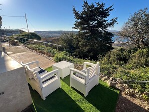 Un patio con mobili bianchi e vista sul paesaggio.